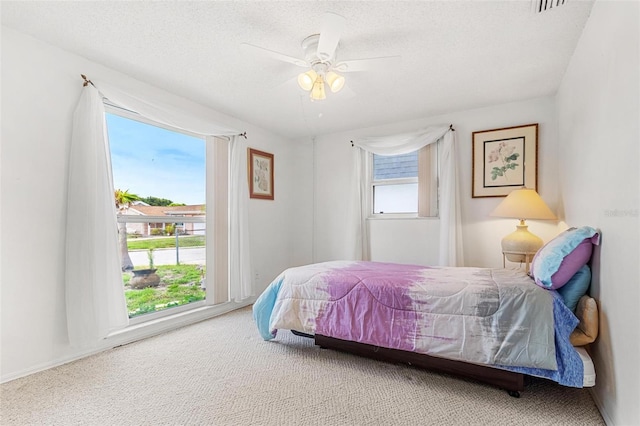 bedroom featuring a textured ceiling, carpet flooring, and a ceiling fan