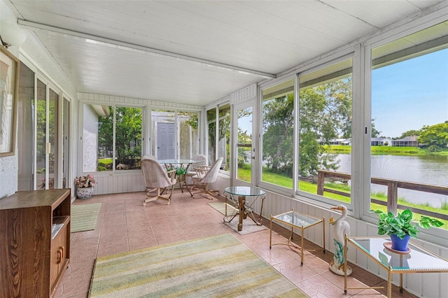 sunroom featuring a water view and a healthy amount of sunlight