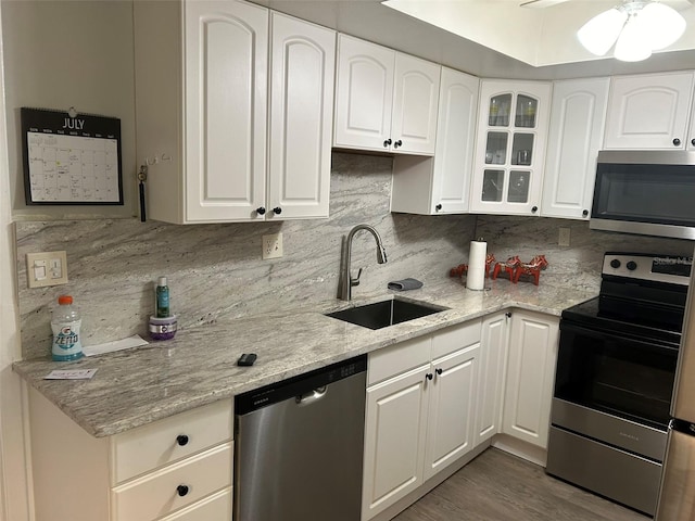 kitchen featuring white cabinetry, ceiling fan, stainless steel appliances, hardwood / wood-style floors, and sink