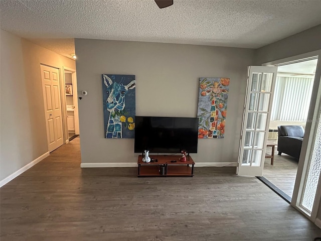 living room featuring a textured ceiling and dark hardwood / wood-style flooring