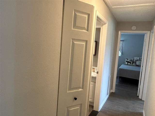 hallway with dark wood-type flooring and a textured ceiling