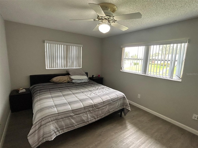 bedroom with wood-type flooring, a textured ceiling, and ceiling fan