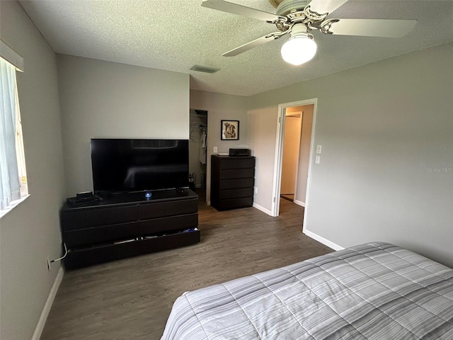 bedroom featuring a textured ceiling, wood-type flooring, and ceiling fan