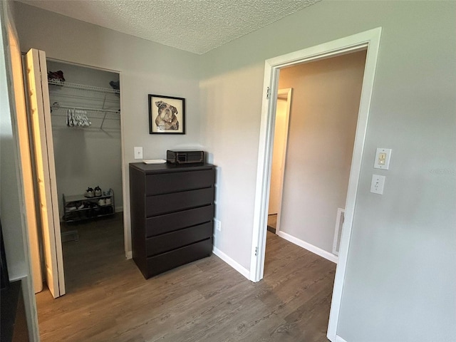 hallway featuring a textured ceiling and hardwood / wood-style floors