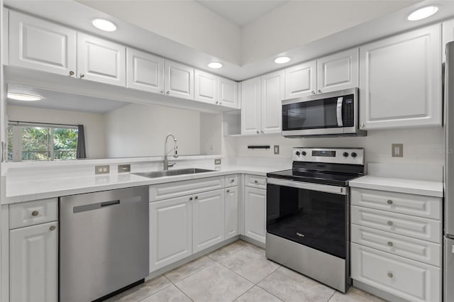 kitchen with white cabinets, appliances with stainless steel finishes, light tile patterned floors, and sink