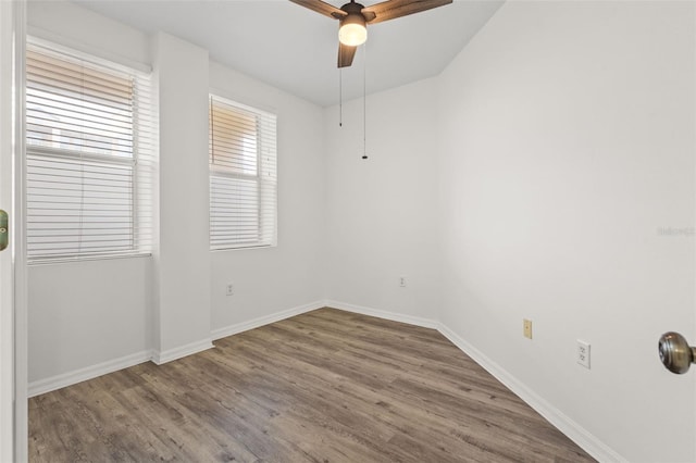 unfurnished room with a ceiling fan, baseboards, and wood finished floors