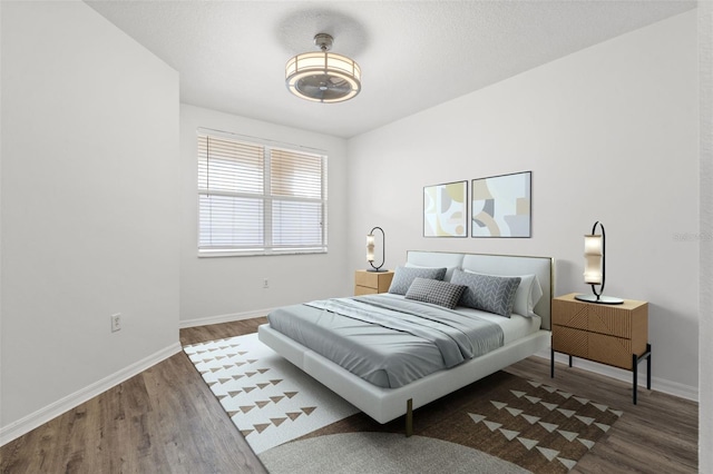 bedroom with baseboards and wood finished floors