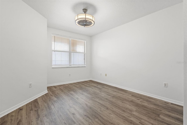 spare room with wood finished floors and baseboards