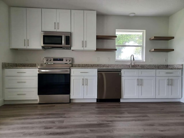 kitchen featuring white cabinets, stainless steel appliances, and dark hardwood / wood-style flooring