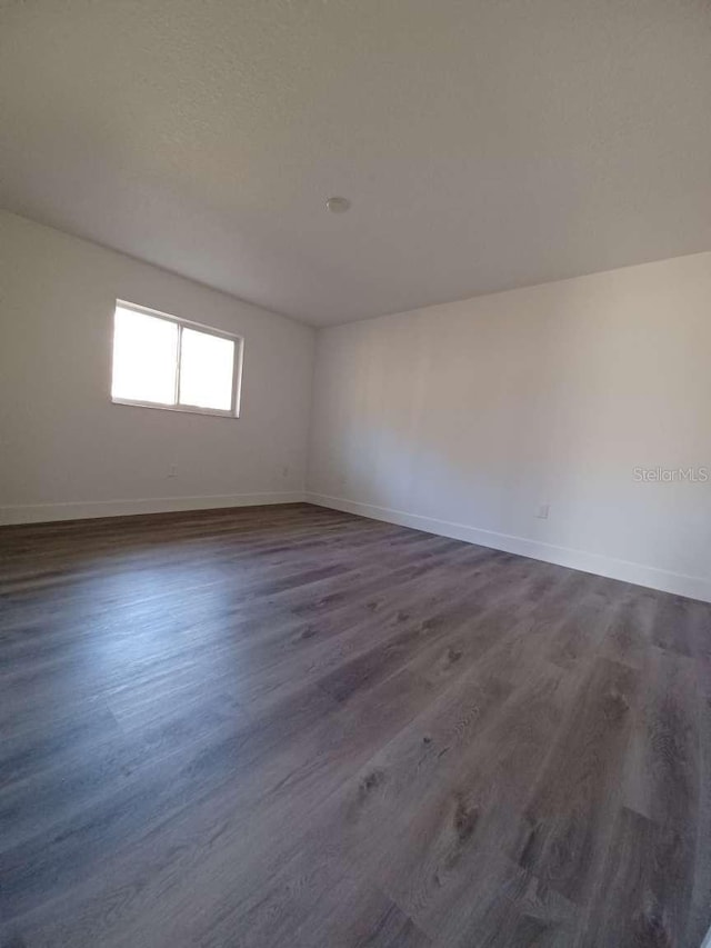 spare room featuring dark wood-type flooring