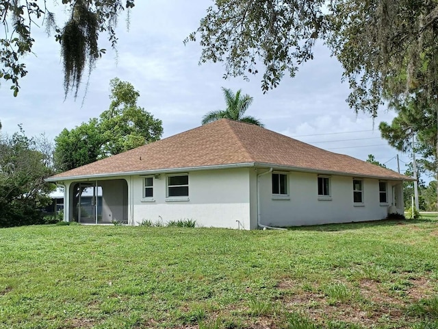 rear view of property featuring a yard and a sunroom