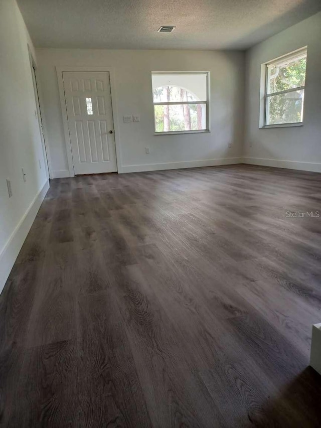 entryway with a textured ceiling and dark hardwood / wood-style floors