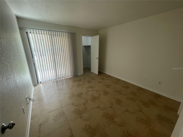 spare room with light tile patterned floors and a textured ceiling