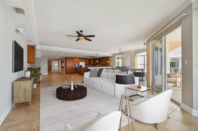 living room featuring light tile patterned floors, ceiling fan with notable chandelier, and ornamental molding