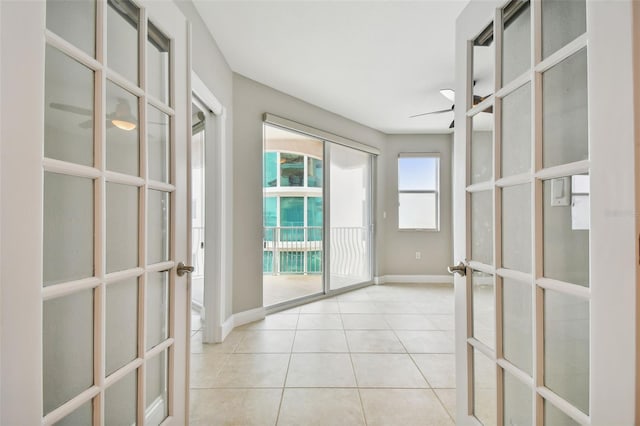 interior space with french doors, ceiling fan, and light tile patterned flooring