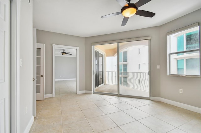 tiled empty room featuring ceiling fan