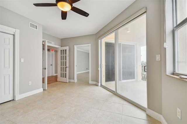 spare room with light tile patterned floors, french doors, and ceiling fan