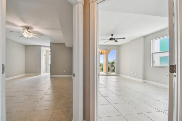 tiled empty room featuring ceiling fan