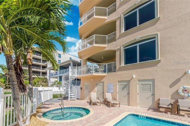 view of pool featuring a patio and a community hot tub