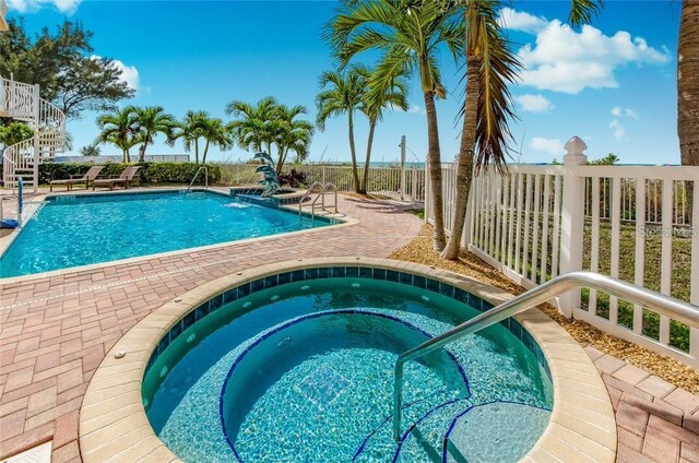 view of swimming pool featuring an in ground hot tub