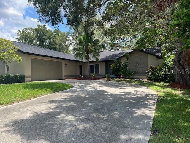 ranch-style house featuring a garage and a front yard