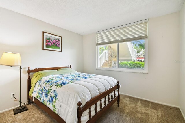 bedroom featuring carpet floors and a textured ceiling