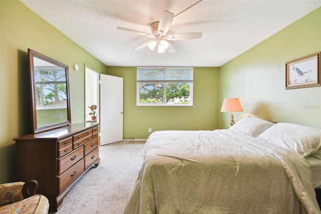 carpeted bedroom featuring a textured ceiling and ceiling fan