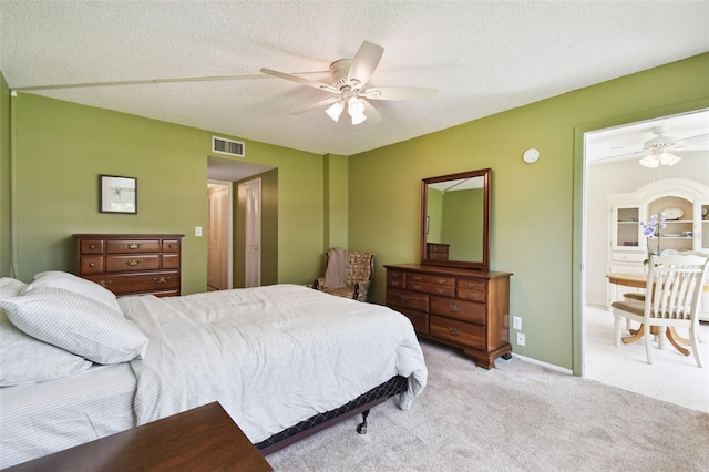 carpeted bedroom featuring a textured ceiling and ceiling fan