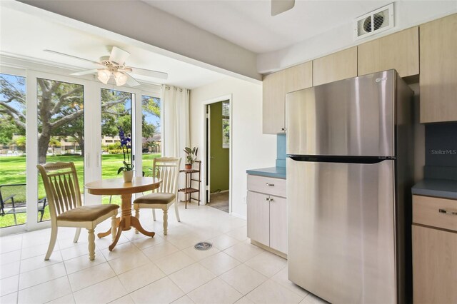 kitchen with ceiling fan, light brown cabinets, stainless steel refrigerator, and light tile patterned floors