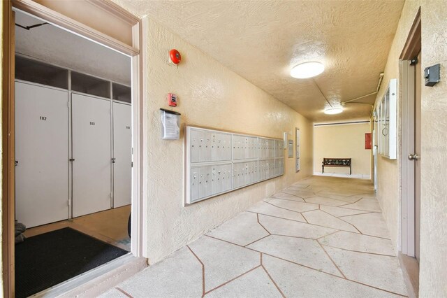 hall with mail boxes and a textured ceiling