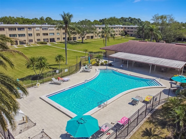 view of swimming pool featuring a patio and a lawn