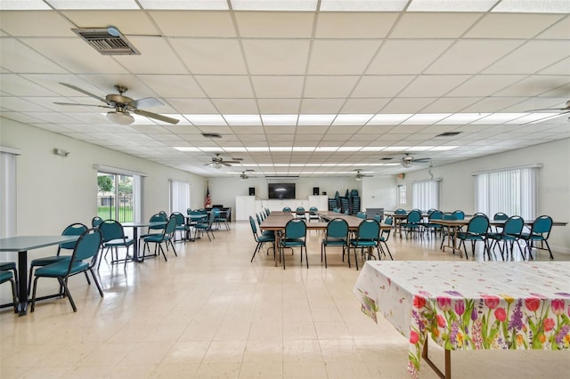 tiled dining room with ceiling fan and a drop ceiling