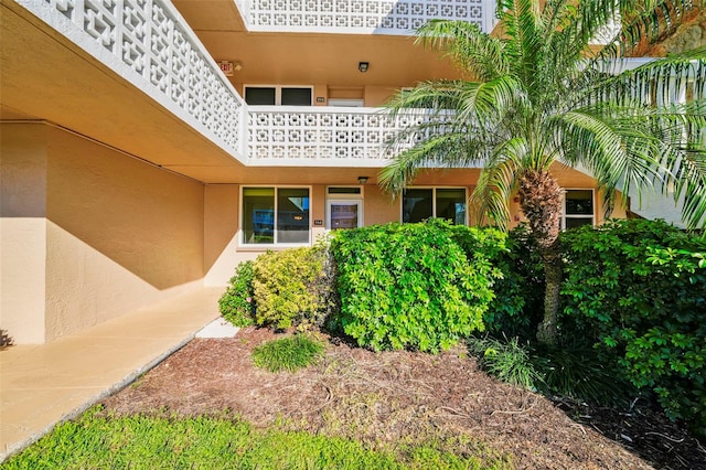 property entrance featuring a balcony and stucco siding