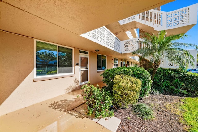 entrance to property featuring stucco siding