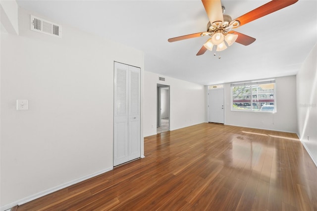 unfurnished room with baseboards, ceiling fan, visible vents, and wood finished floors