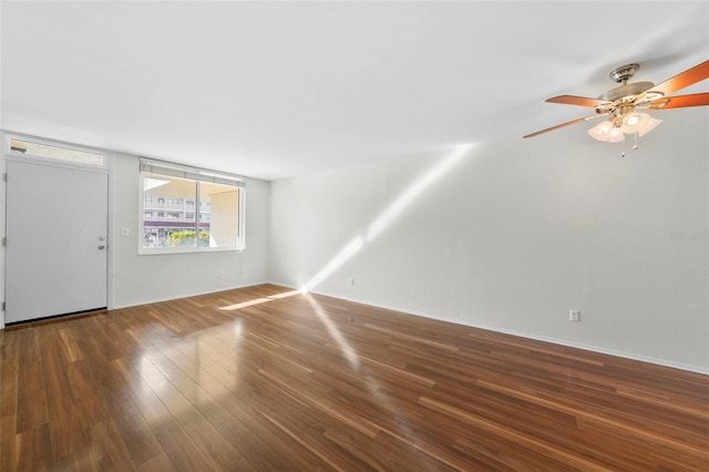 interior space featuring a ceiling fan, baseboards, and wood finished floors