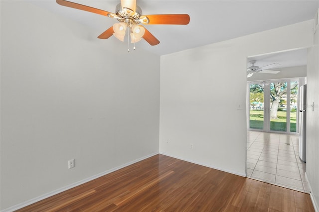 spare room featuring baseboards and wood finished floors