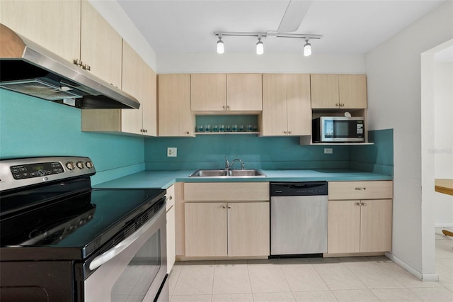 kitchen featuring under cabinet range hood, stainless steel appliances, a sink, light countertops, and light brown cabinetry