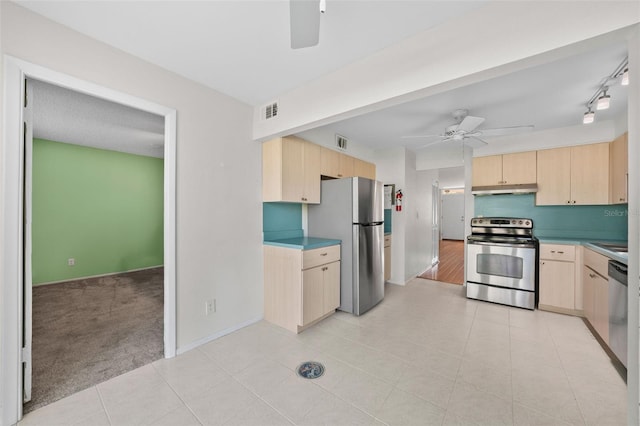 kitchen featuring stainless steel appliances, light brown cabinets, under cabinet range hood, and a ceiling fan