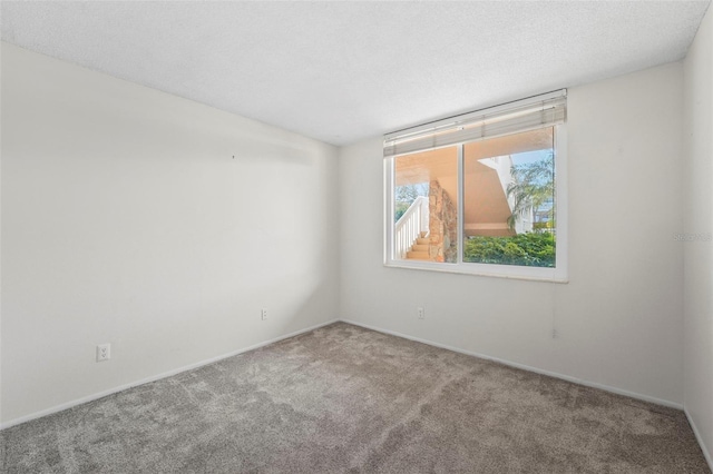 carpeted spare room featuring a textured ceiling