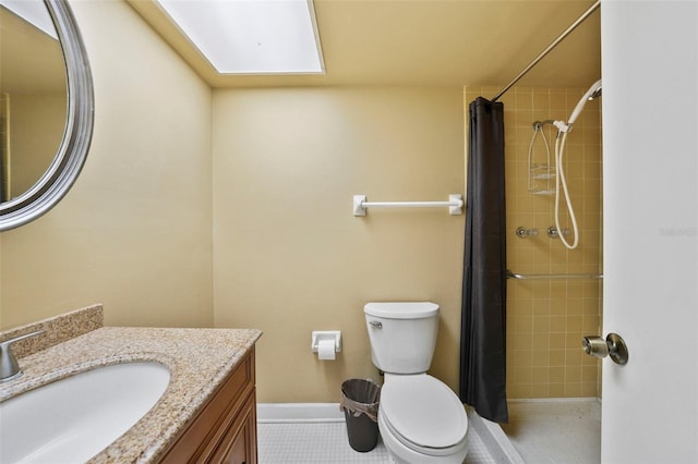 full bath featuring baseboards, tiled shower, vanity, and toilet