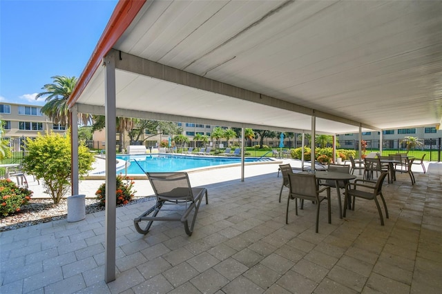 pool with a patio area and fence