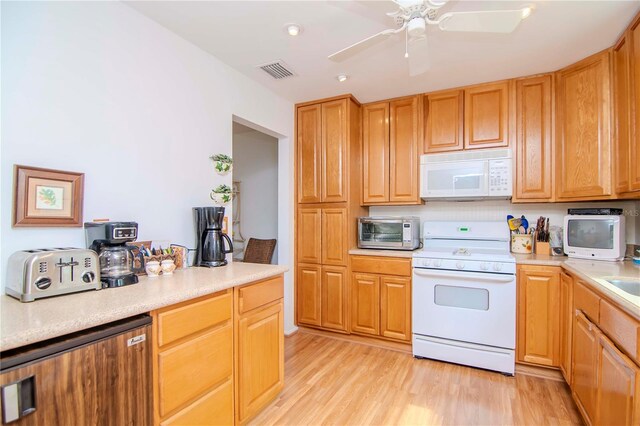 kitchen featuring light wood-type flooring, ceiling fan, sink, and white appliances