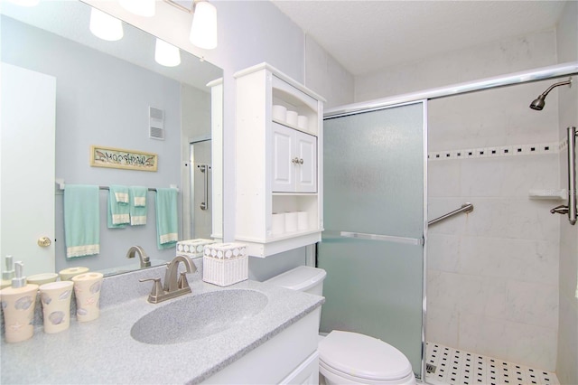 bathroom featuring toilet, vanity, and an enclosed shower