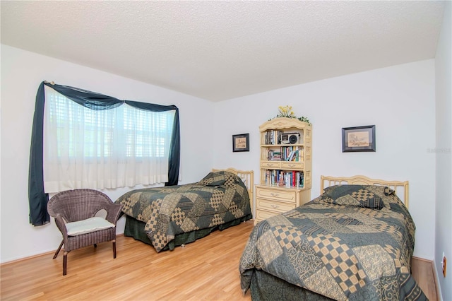 bedroom with hardwood / wood-style flooring and a textured ceiling