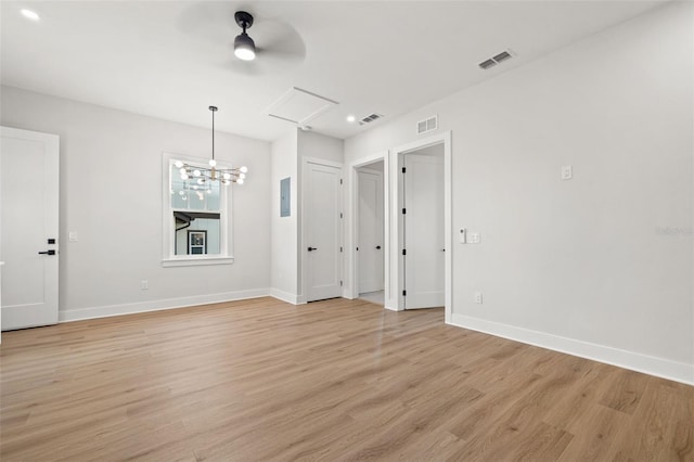 unfurnished room with light wood-type flooring and ceiling fan with notable chandelier