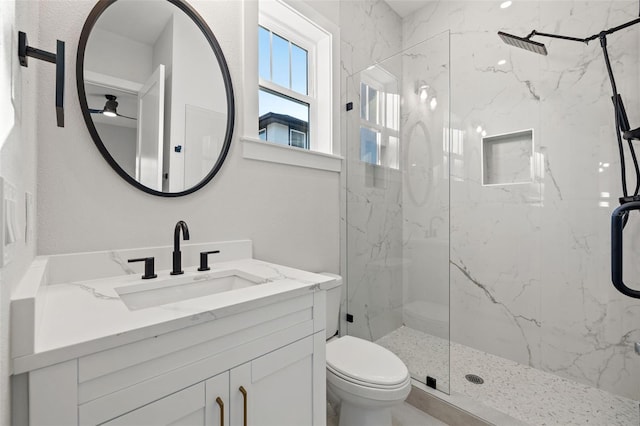 bathroom featuring toilet, a shower with door, and vanity