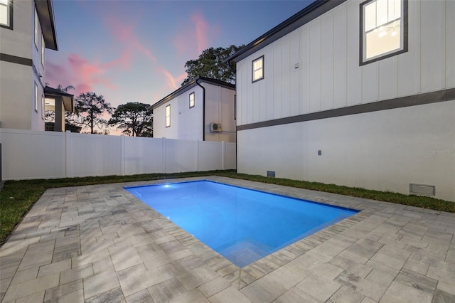 pool at dusk featuring a patio