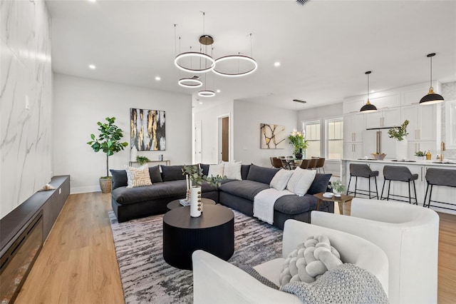 living room with a notable chandelier and light hardwood / wood-style flooring