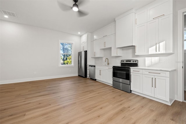 kitchen featuring white cabinets, appliances with stainless steel finishes, light hardwood / wood-style flooring, and sink